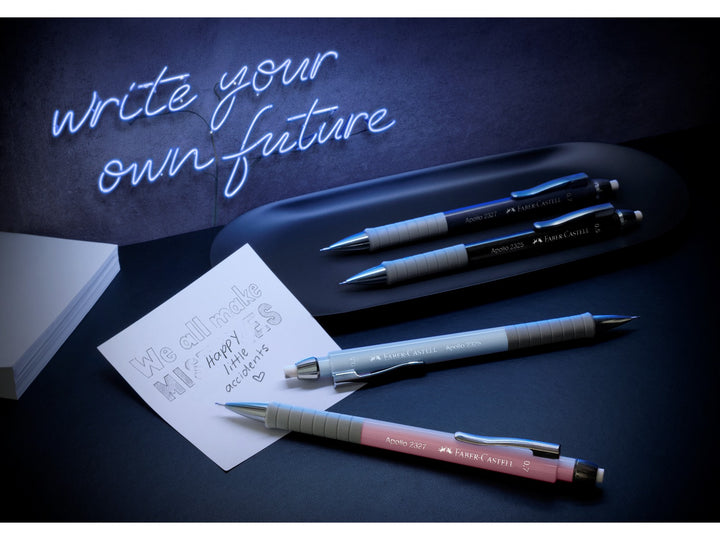 Faber-Castell Apollo Mechanical Pencils in Dark Blue, Black and Pale Rose displayed with study notes beneath a neon “write your own future” sign, showcasing the ergonomic soft-grip zone, retractable lead sleeve, integrated eraser and 0.7mm lead for everyday writing, note-taking, studying and technical drawing.