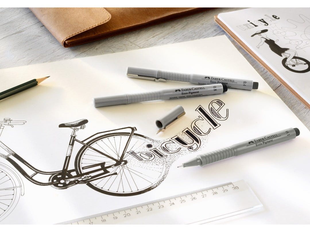 Lifestyle image featuring Faber-Castell Ecco Pigment fineliners in multiple line widths alongside a detailed bicycle illustration, ruler, sketchbook and drawing tools, demonstrating the document-proof pigment ink, precision metal-clad tips and suitability for technical drawing, illustration, sketching and drafting.