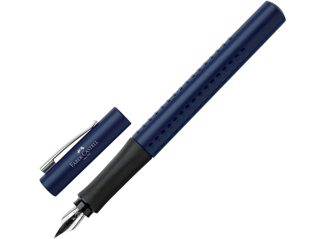Faber-Castell Grip 2011 Fountain Pen in Classic Blue shown writing a handwritten letter on white paper, featuring an ergonomic triangular barrel with patented Grip dots, durable stainless steel nib and metal pocket clip for comfortable everyday handwriting, journaling, note-taking and professional writing.