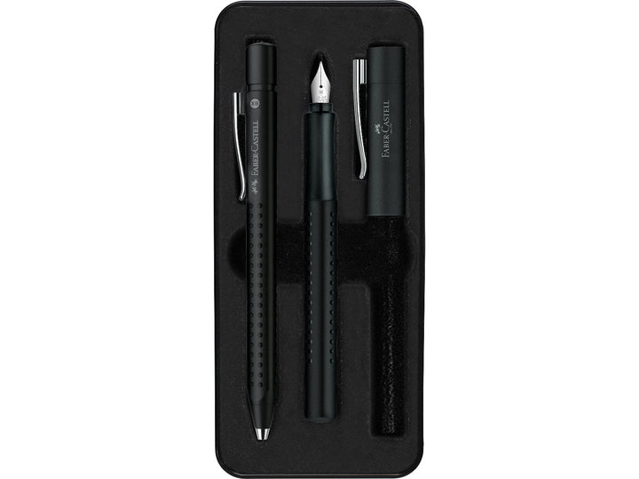 Close-up of the Faber-Castell Grip 2011 Fountain Pen Gift Set Black 2 Pieces displayed inside its presentation tray, featuring a matching black fountain pen with stainless steel nib and coordinating ballpoint pen, both with ergonomic Grip dot barrels, metal clips and comfortable everyday writing design.