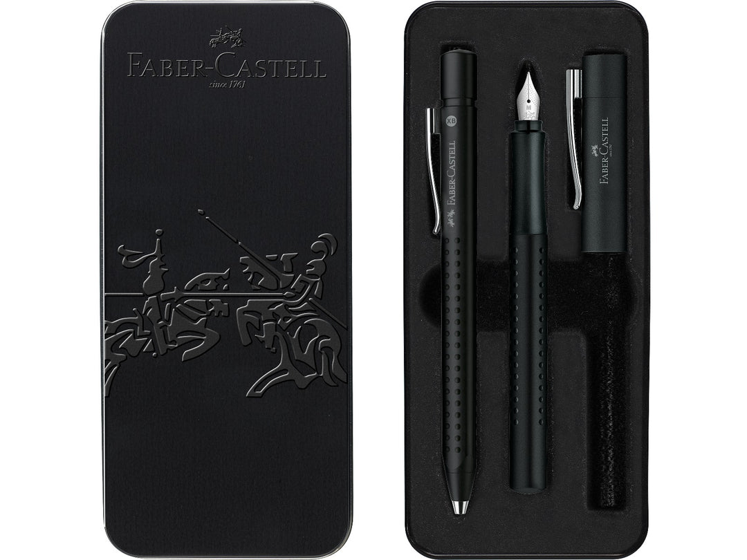 Front and open Faber-Castell Grip 2011 Fountain Pen Gift Set Black 2 Pieces presentation tin, showing a matching black fountain pen with stainless steel nib and coordinating ballpoint pen with ergonomic Grip dot barrels, supplied in a premium metal gift box for everyday writing, journaling and professional use.