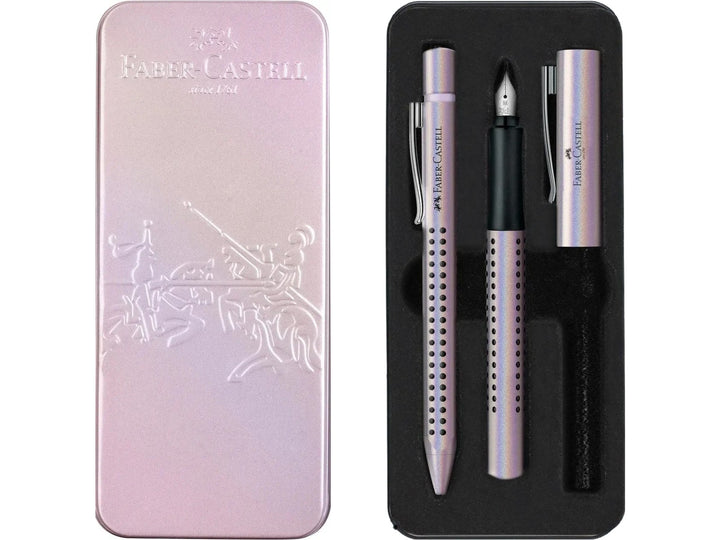 Front and open Faber-Castell Grip Edition Glam Writing Set Pearl presentation tin, showing a matching pearl-effect fountain pen with stainless steel nib and coordinating ballpoint pen with ergonomic Grip dot barrels, supplied in a premium metallic pink gift box for everyday writing, journaling, note-taking and gifting.