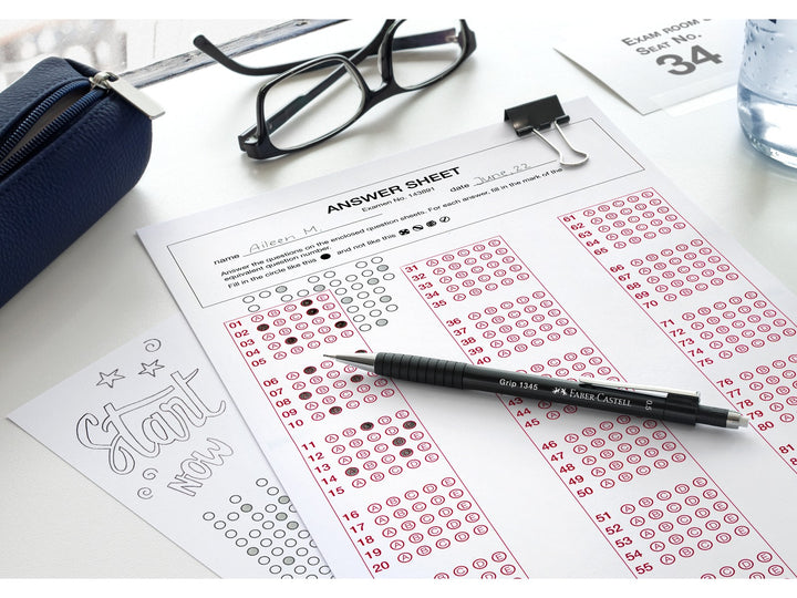 Faber-Castell Grip 1345 Mechanical Pencil 0.5mm in a classroom and study setting, featuring a cushioned lead sleeve to reduce breakage, non-slip rubber grip zone, retractable lead mechanism and extra-long twist-out eraser, shown completing a multiple-choice answer sheet for note-taking, revision and exam preparation.