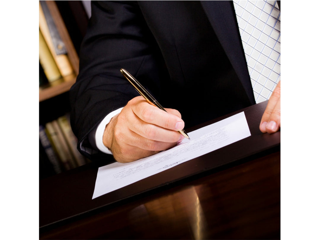 Fisher Space Pen Bullet chrome pen used for signing document on desk in professional setting