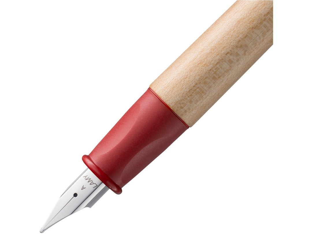 LAMY abc fountain pen close-up showing red ergonomic non-slip grip section, maple wood barrel and beginner-friendly stainless steel A nib
