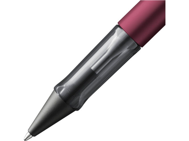 Close-up of the LAMY AL-star ballpoint pen in Black Purple, showing the transparent ergonomic grip section, anodised aluminium barrel and retractable ballpoint tip