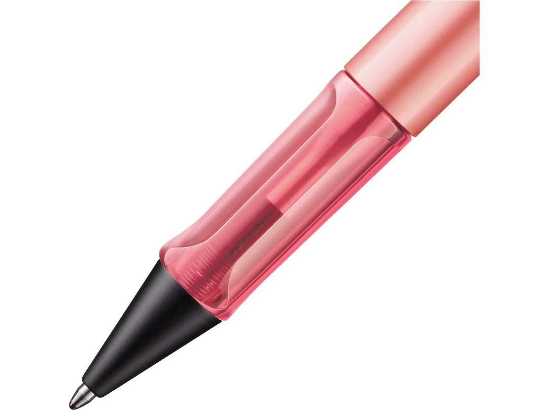 Close-up of the LAMY AL-star ballpoint pen in Flamingo Special Edition, showing the transparent pink ergonomic grip section, anodised aluminium barrel and retractable ballpoint tip