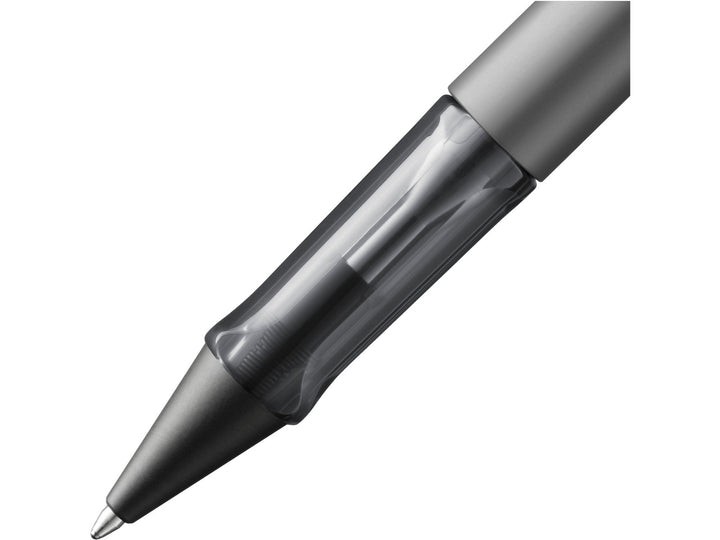 Close-up of the LAMY AL-star ballpoint pen in Graphite, showing the transparent ergonomic grip section, anodised aluminium barrel and retractable ballpoint tip