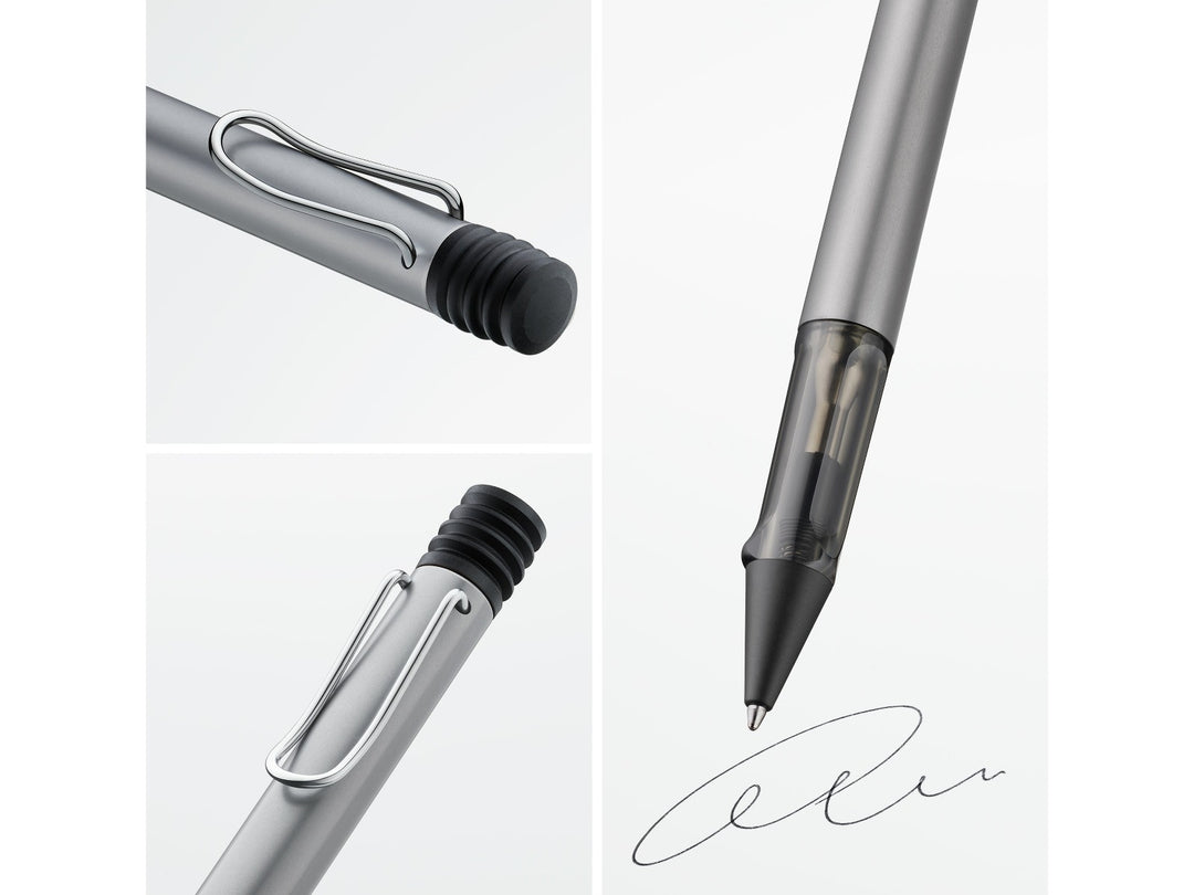 Close-up details of the LAMY AL-star ballpoint pen in Graphite, highlighting the self-sprung metal clip, translucent smoke-grey ergonomic grip section, anodised aluminium body and retractable ballpoint writing tip