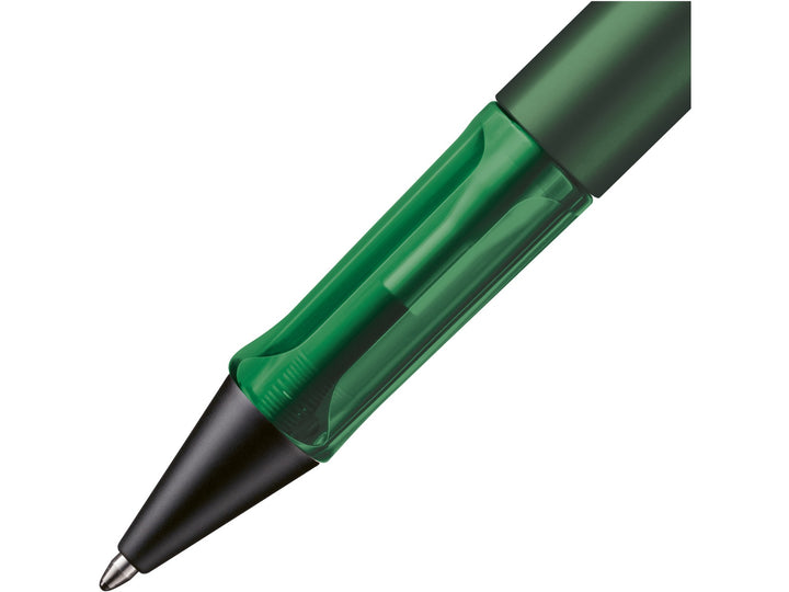 Close-up of the LAMY AL-star ballpoint pen in Pine Special Edition, showing the transparent green ergonomic grip section, anodised aluminium barrel and retractable ballpoint tip