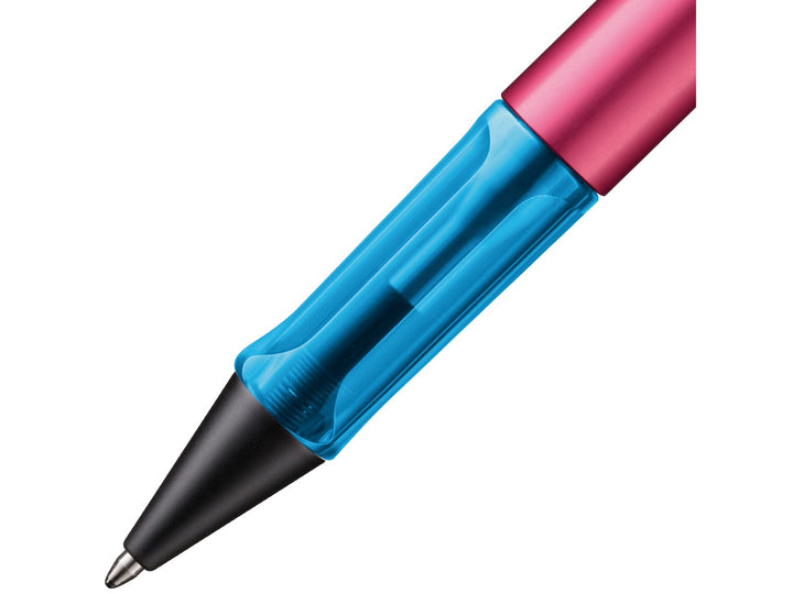 Close-up of the LAMY AL-star ballpoint pen in Rollerskate Special Edition, showing the transparent blue ergonomic grip section, anodised aluminium barrel and retractable ballpoint tip