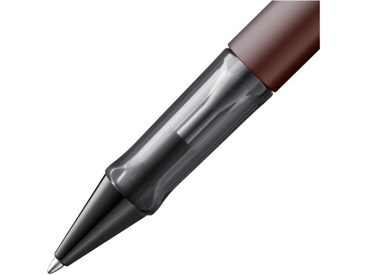 Close-up of the LAMY Lx ballpoint pen in marron, showing the transparent ergonomic grip section, anodised aluminium barrel and precision ballpoint writing tip