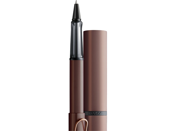 Close-up of the LAMY Lx ballpoint pen in marron alongside its matching aluminium presentation case, highlighting the anodised aluminium finish, transparent ergonomic grip section and colour-matched premium detailing