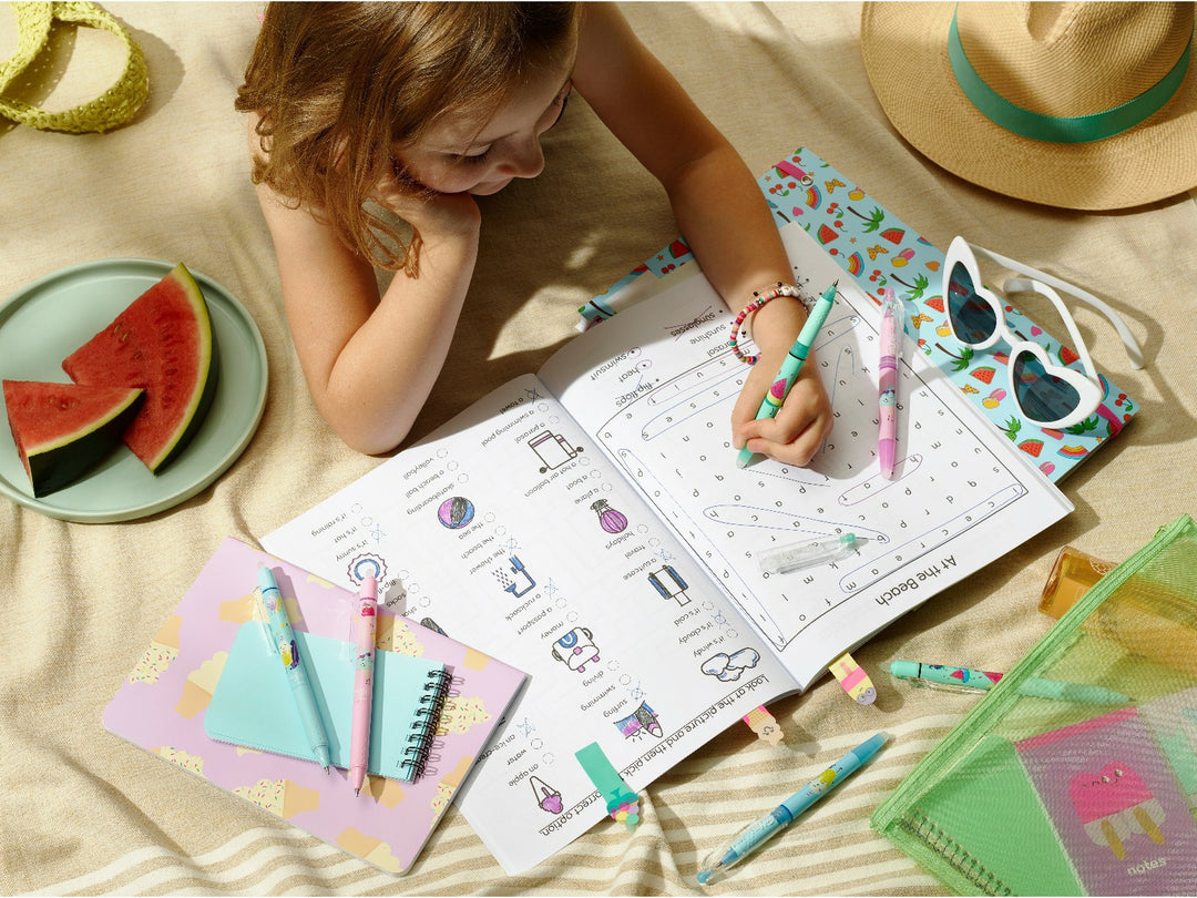 Pilot FriXion Ball 0.7 Pool Party Edition erasable rollerball pens being used for a summer activity book alongside colourful notebooks, stationery, sunglasses and watermelon