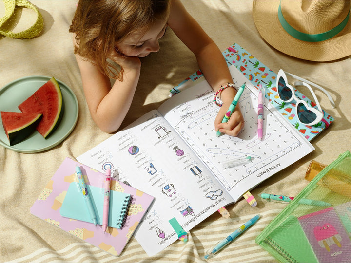 Pilot FriXion Ball 0.7 Pool Party Edition erasable rollerball pens being used for a summer activity book alongside colourful notebooks, stationery, sunglasses and watermelon