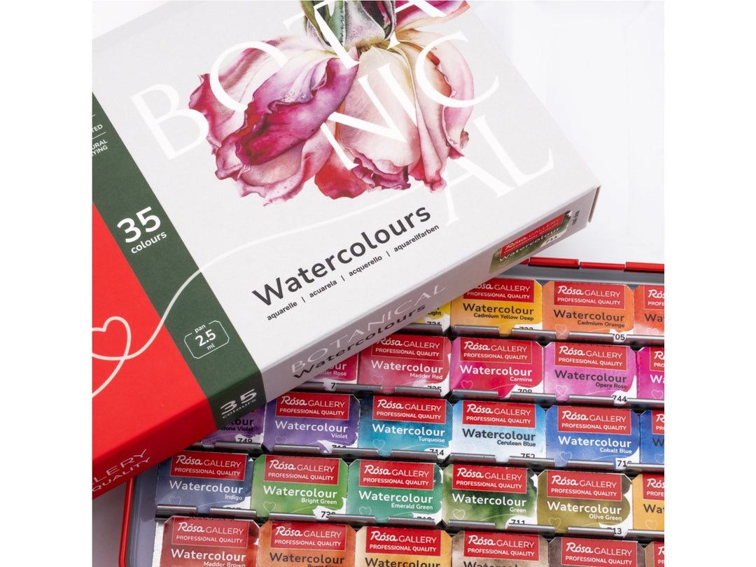 Close-up of the ROSA Gallery Botanical Watercolour Set featuring updated Botanical Collection packaging resting above an open metal watercolour case filled with 35 professional watercolour half pans. The image highlights the extensive botanical colour selection, floral-themed packaging artwork and artist-quality watercolours developed for botanical illustration, floral painting and detailed nature studies