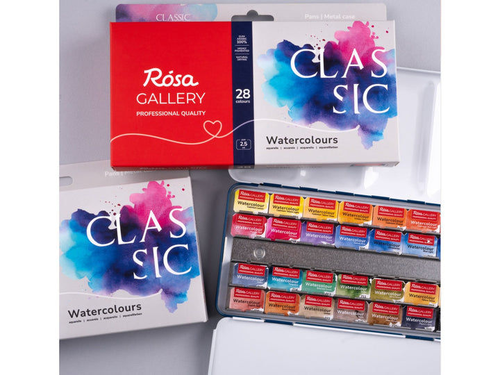 Lifestyle image of the ROSA Gallery Classic Watercolour Set featuring updated Classic Collection packaging alongside an open metal watercolour case filled with 28 professional watercolour half pans. The image showcases the integrated mixing palette, vibrant colour selection and versatile artist palette designed for watercolour painting, sketching and illustration