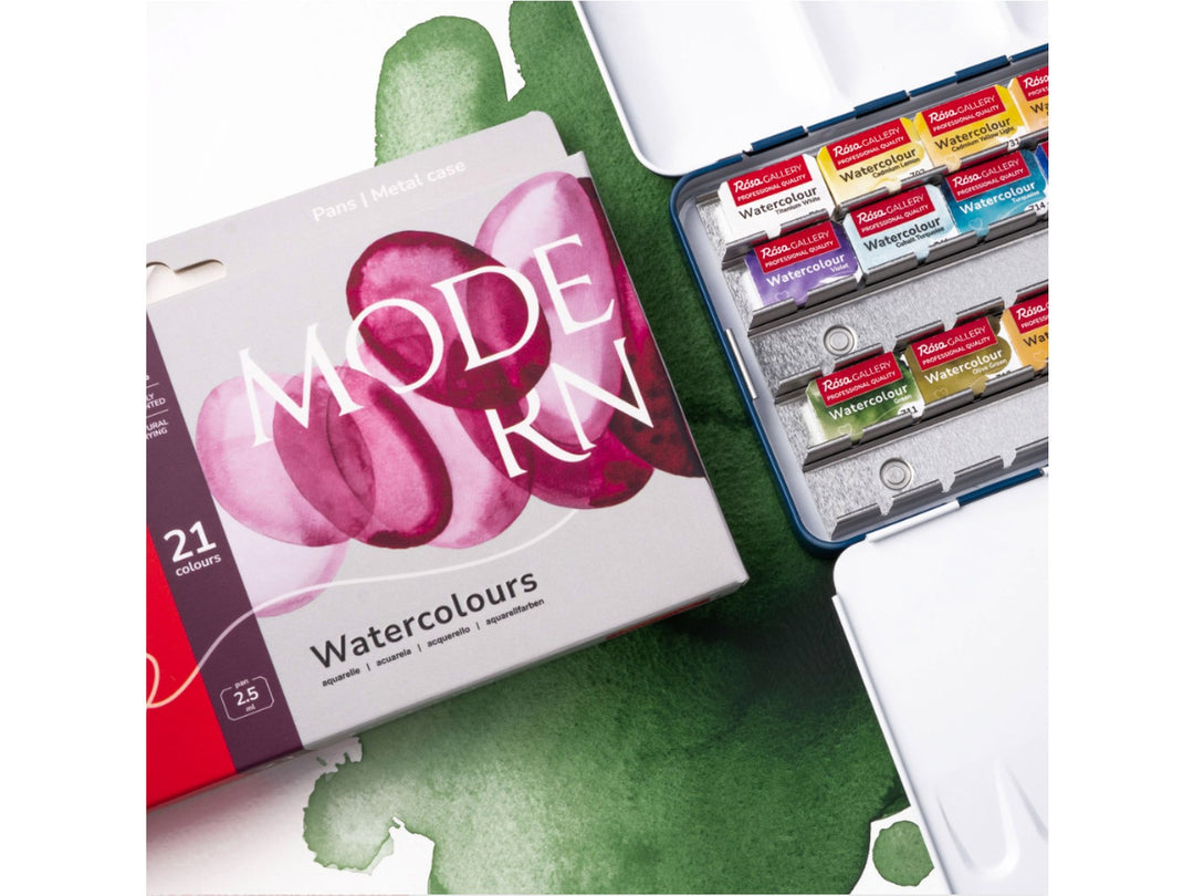 Lifestyle image of the ROSA Gallery Modern Watercolour Set featuring updated Modern Collection packaging alongside an open metal watercolour case filled with 21 professional watercolour half pans. The image showcases vibrant green watercolour washes, integrated mixing palette surfaces and a contemporary colour selection developed for illustration, urban sketching and modern watercolour painting