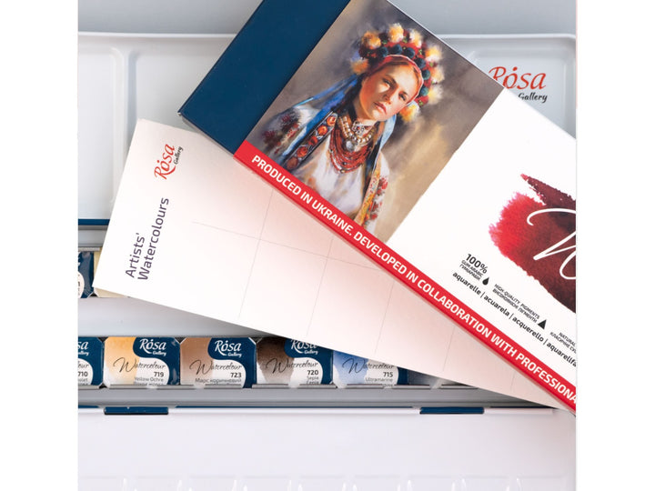 Close-up of the ROSA Gallery Portrait Watercolour Set featuring portrait-themed packaging artwork positioned above an open metal watercolour case, showcasing professional watercolour pans, integrated mixing palette surfaces and a curated colour selection developed for portrait painting, skin tone mixing and figurative artwork