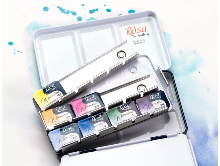 Rosa Gallery watercolour set in open tin showing paint pans with blue watercolour splashes
