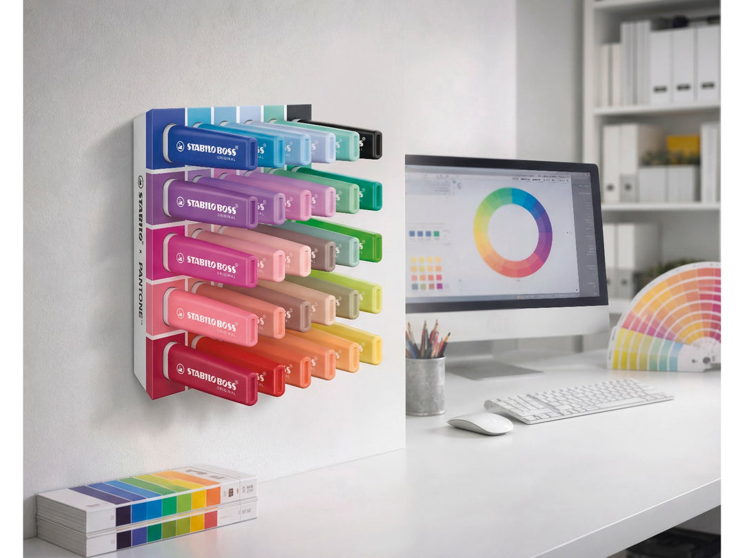 STABILO BOSS ORIGINAL x PANTONE desk set of 30 highlighters mounted on a wall in a modern creative workspace with colour wheel displayed on a computer screen