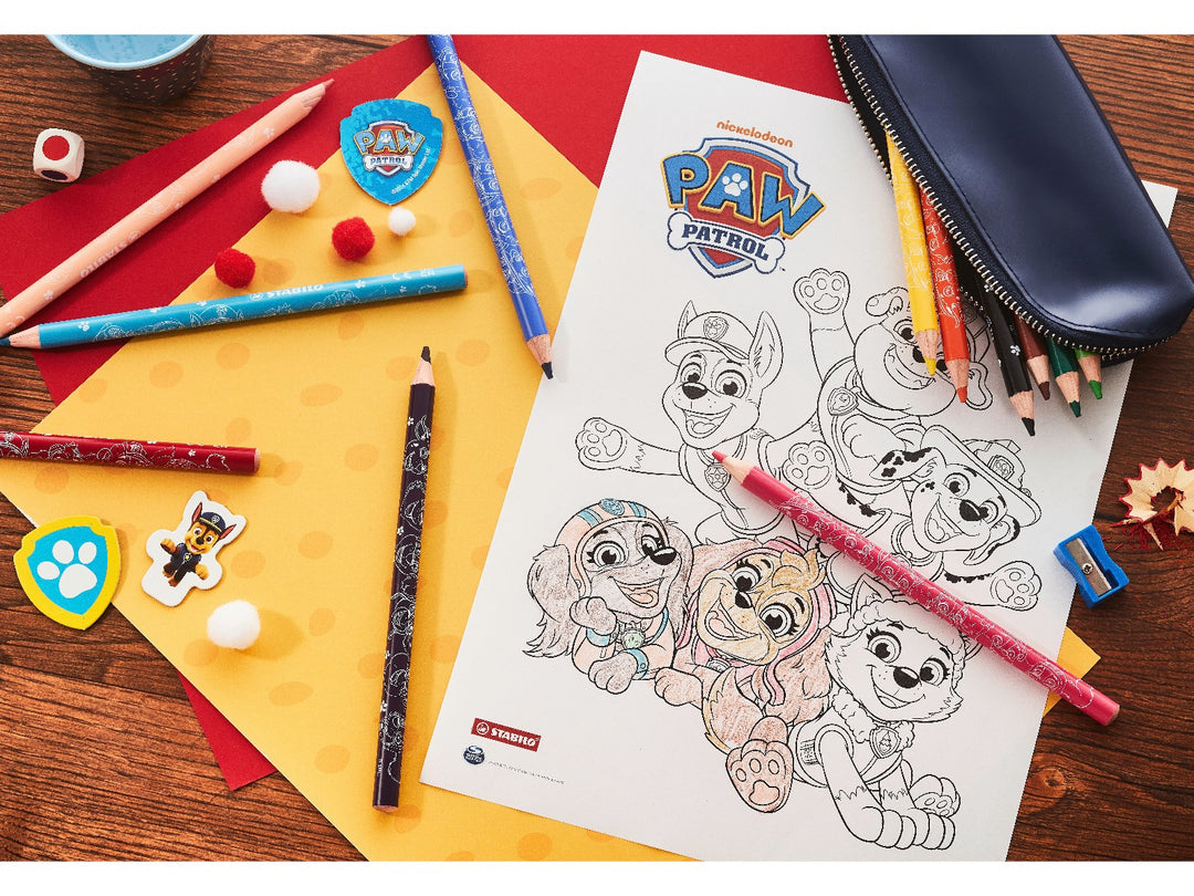 STABILO coloured pencils in assorted bright colours arranged around a PAW Patrol colouring sheet, with pencil case, sharpener and colourful craft accessories on a wooden desk