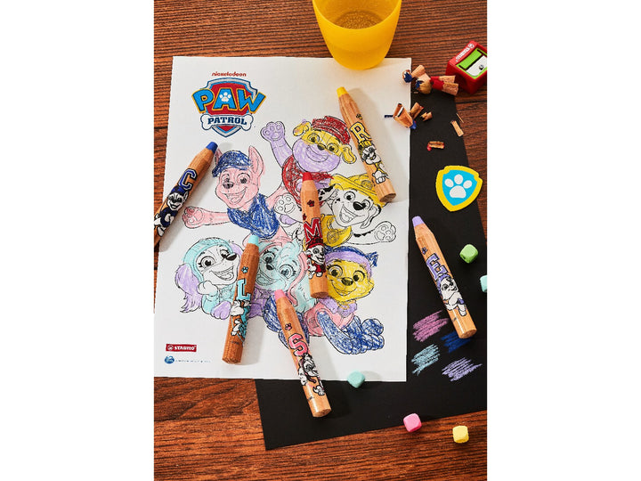 STABILO woody 3 in 1 PAW Patrol pencils in assorted colours displayed around a PAW Patrol colouring sheet, with colour swatches, pencil shavings and sharpener