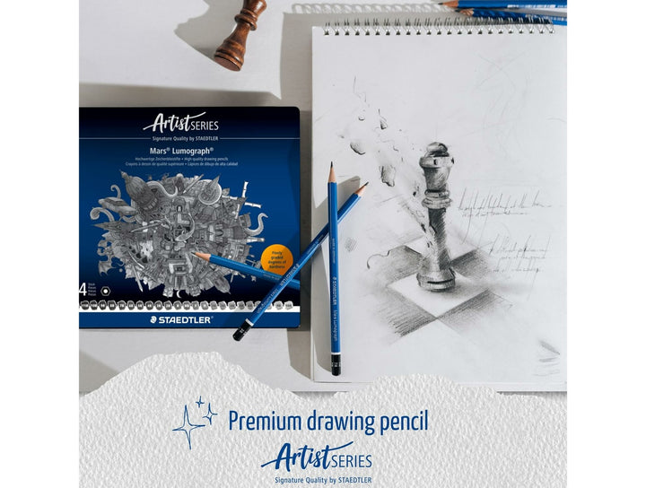 STAEDTLER Mars Lumograph 100 graphite pencil set shown with tin and artwork demonstrating premium sketching and shading
