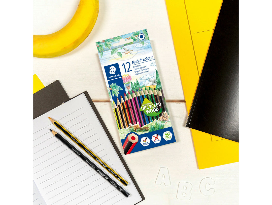 STAEDTLER Noris Colour 185 coloured pencils 12 pack on desk with notebook and school supplies