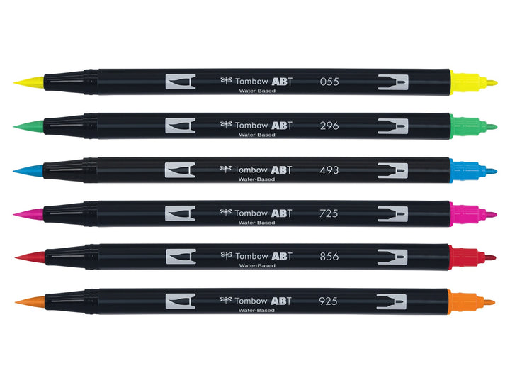 Tombow ABT Dual Brush Pen Dermatologically Tested Colours Set of 6 displayed individually, featuring Process Yellow (055), Green (296), Reflex Blue (493), Rhodamine Red (725), Poppy Red (856) and Scarlet (925), each with dual brush and fine tips visible for hand lettering, colouring, journaling, illustration and watercolour-style effects.