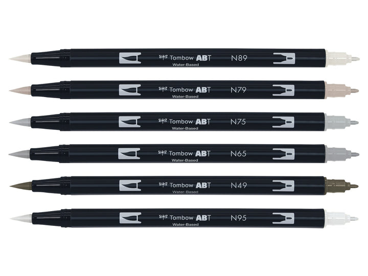 Tombow ABT Dual Brush Pen Grey Colours Set of 6 displayed individually, featuring Warm Grey 1 (N89), Warm Grey 2 (N79), Cool Grey 3 (N75), Cool Grey 5 (N65), Warm Grey 8 (N49) and Cool Grey 8 (N95), each with dual brush and fine tips visible for sketching, shading, hand lettering, illustration and monochrome artwork.