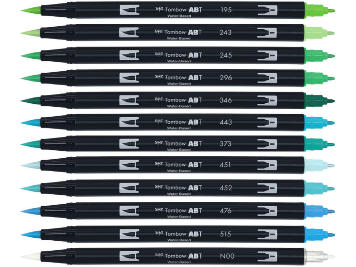 Tombow ABT Dual Brush Pen Ocean Colours Set of 12 displayed individually, featuring Light Green, Mint, Sap Green, Green, Sea Green, Turquoise, Sea Blue, Sky Blue, Process Blue, Cyan and Light Blue shades plus a colourless blender pen, each with dual brush and fine tips visible.