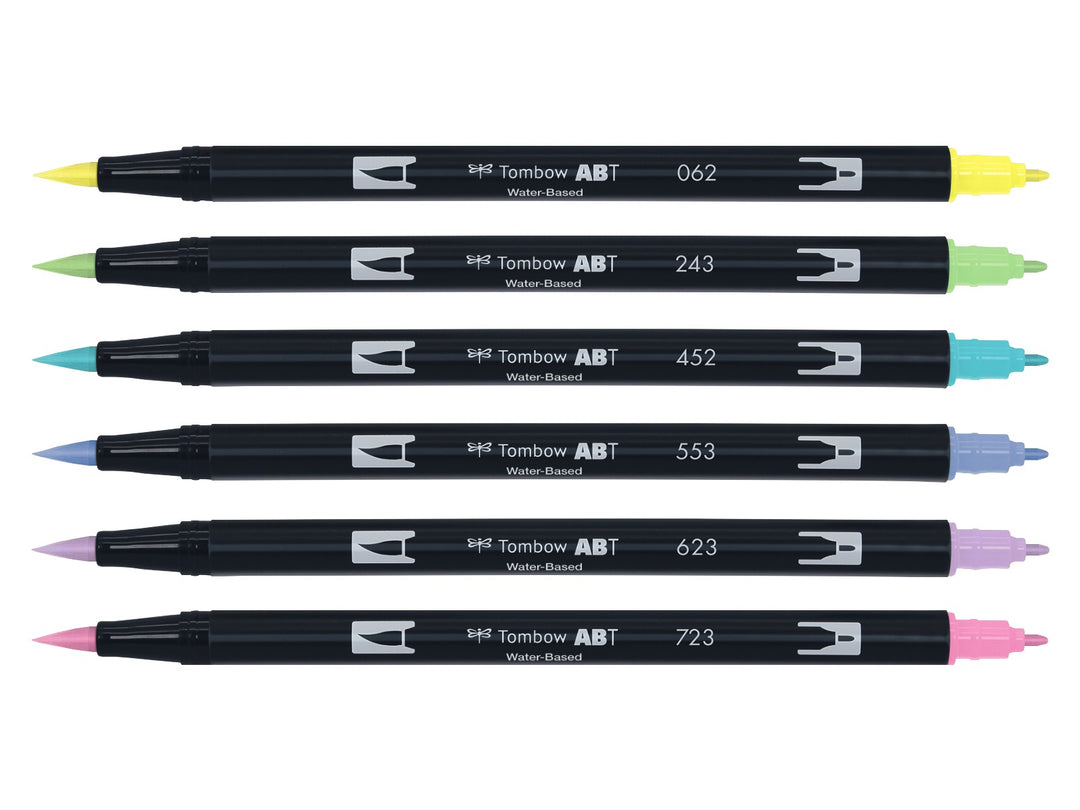 Tombow ABT Dual Brush Pen Pastel Colours Set of 6 displayed individually, featuring Pale Yellow (062), Mint (243), Process Blue (452), Mist Purple (553), Purple Sage (623) and Pink (723), each with dual brush and fine tips visible for hand lettering, colouring, journaling, illustration and watercolour-style effects.