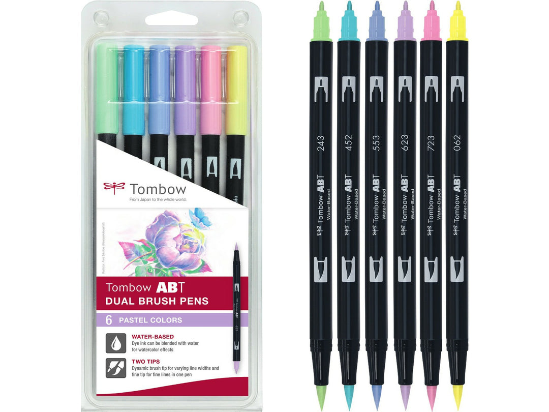 Tombow ABT Dual Brush Pen Pastel Colours Set of 6 featuring Pale Yellow (062), Mint (243), Process Blue (452), Mist Purple (553), Purple Sage (623) and Pink (723), displayed alongside the original retail packaging with dual brush and fine tips for hand lettering, colouring, journaling and illustration.
