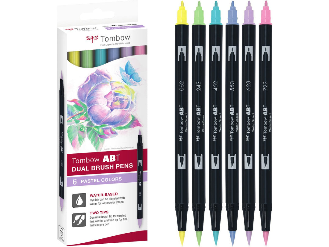 Tombow ABT Dual Brush Pen Pastel Colours Set of 6 featuring Pale Yellow (062), Mint (243), Process Blue (452), Mist Purple (553), Purple Sage (623) and Pink (723), displayed alongside the original retail packaging with dual brush and fine tips for hand lettering, colouring, journaling and illustration.