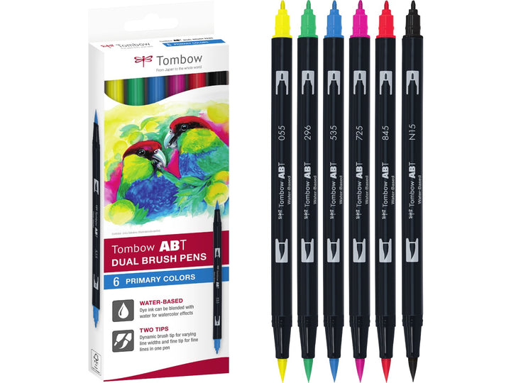 Tombow ABT Dual Brush Pen Primary Colours Set of 6 featuring Black (N15), Process Yellow (055), Green (296), Cobalt Blue (535), Rhodamine Red (725) and Carmine (845), displayed alongside the original retail packaging with dual brush and fine tips for hand lettering, colouring, illustration and creative projects.