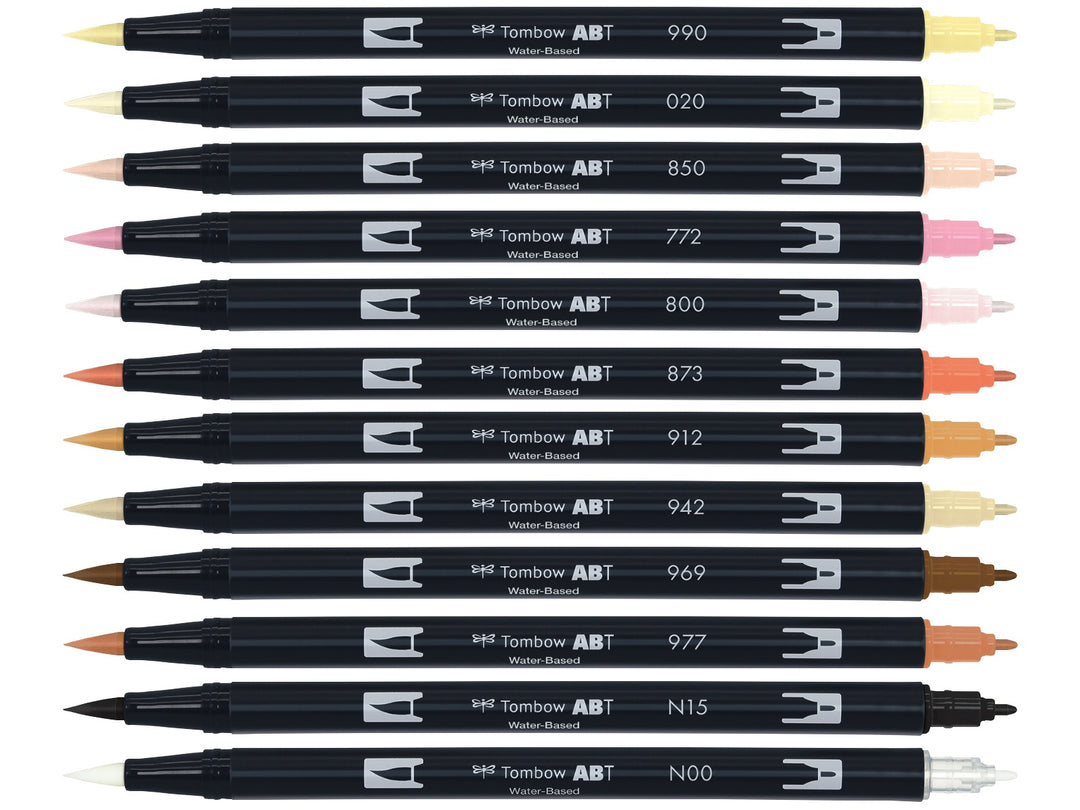 Tombow ABT Dual Brush Pen Skin Tones Set of 12 displayed individually, featuring Light Sand (990), Peach (020), Flesh (850), Blush (772), Baby Pink (800), Coral (873), Pale Cherry (912), Tan (942), Chocolate (969), Saddle Brown (977), Black (N15) and Blender (N00), each with dual brush and fine tips visible for portrait illustration, colouring and creative artwork.