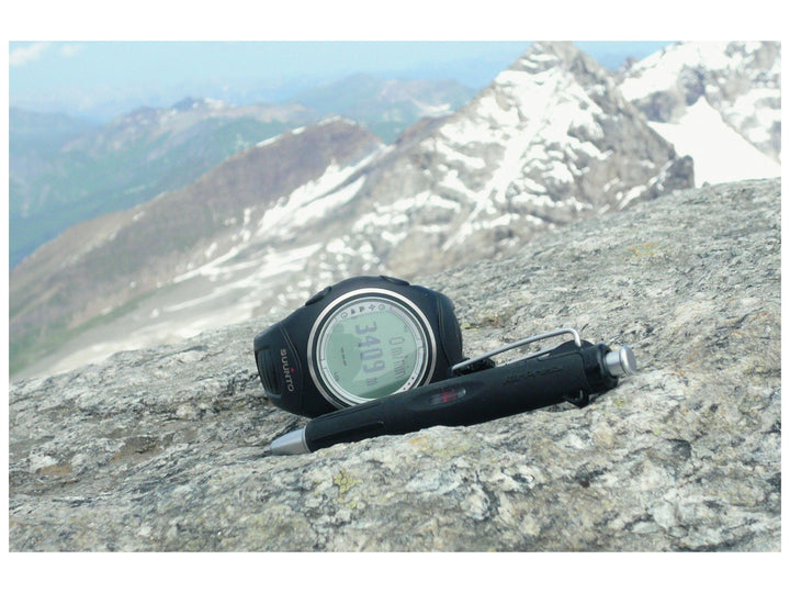 Tombow AirPress ballpoint pen placed beside outdoor navigation equipment in a mountain environment, demonstrating reliable writing performance in cold and demanding conditions