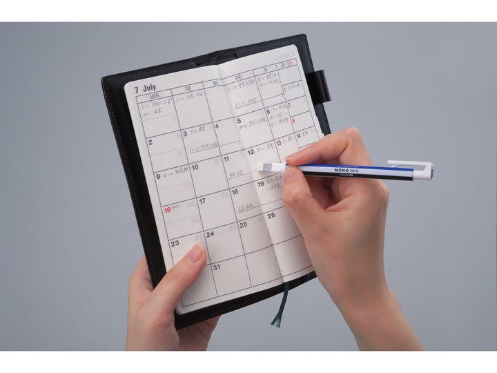 Tombow MONO Zero precision eraser being used to make detailed corrections in a planner, demonstrating accurate erasing with the 2.5 x 5mm rectangular eraser tip