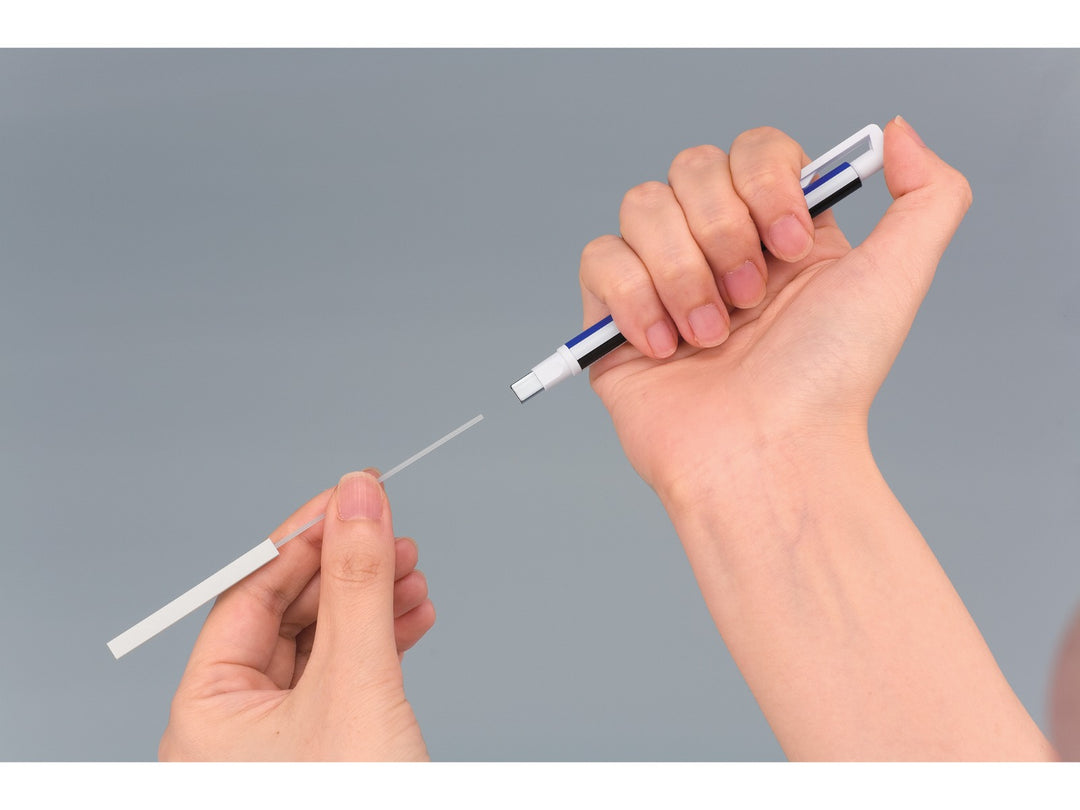 Tombow MONO Zero precision eraser showing the refill replacement process, with rectangular eraser refill being inserted into the pen-style barrel via the push-button mechanism