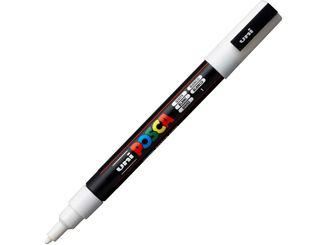 White uni POSCA PC-3M fine water-based paint marker shown diagonally with cap attached, featuring a 0.9–1.3mm bullet tip for lettering, illustration and creative projects