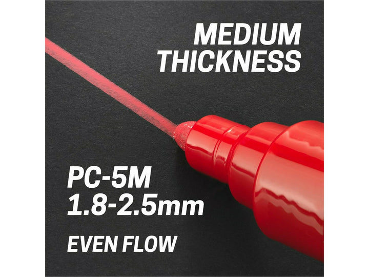 uni POSCA PC-5M medium bullet tip applying a 1.8–2.5mm line on a black surface, demonstrating even paint flow and medium line thickness