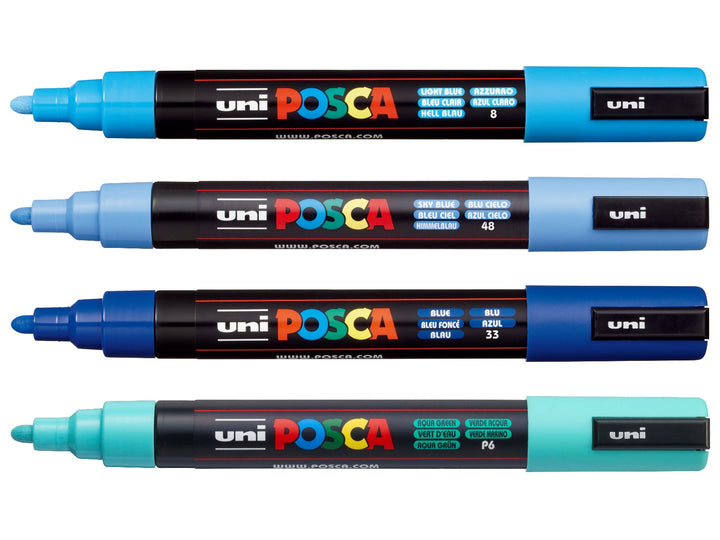 Four uni POSCA PC-5M paint markers shown uncapped in Light Blue, Sky Blue, Blue and Aqua Green, arranged together on a white background